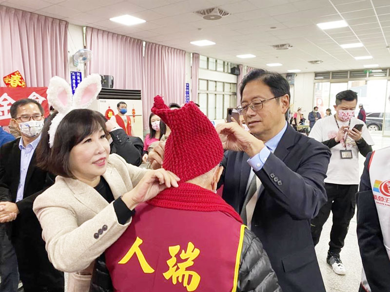 桃園市長張善政與立委呂玉玲替人瑞爺爺圍上圍巾、戴毛帽送暖。（蔡明亘攝）